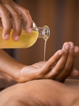 Therapist pouring massage oil at spa