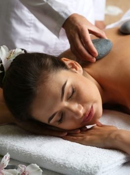 Young woman on massage table in beauty spa salon